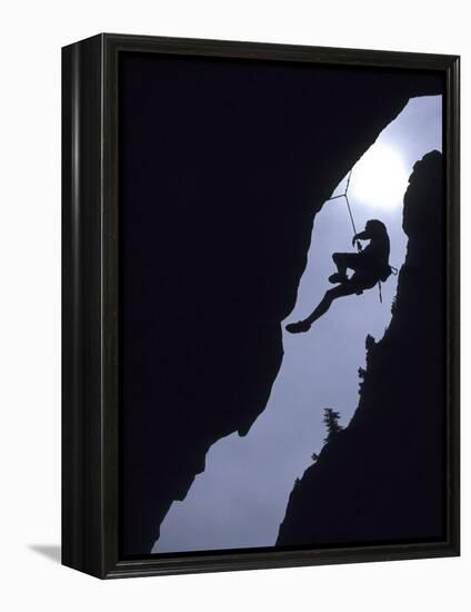 Silhouette of Rock Climber Hanging from Cliff Face-null-Framed Premier Image Canvas
