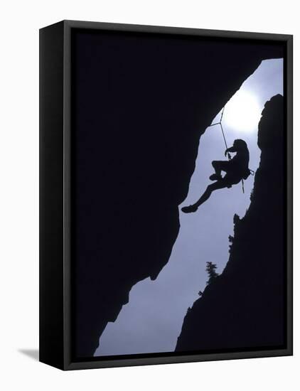 Silhouette of Rock Climber Hanging from Cliff Face-null-Framed Premier Image Canvas