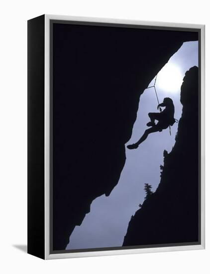 Silhouette of Rock Climber Hanging from Cliff Face-null-Framed Premier Image Canvas