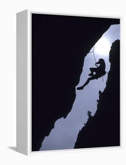 Silhouette of Rock Climber Hanging from Cliff Face-null-Framed Premier Image Canvas