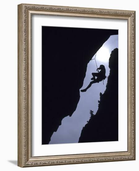 Silhouette of Rock Climber Hanging from Cliff Face-null-Framed Photographic Print