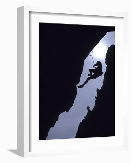 Silhouette of Rock Climber Hanging from Cliff Face-null-Framed Photographic Print