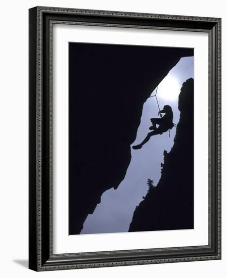 Silhouette of Rock Climber Hanging from Cliff Face--Framed Photographic Print