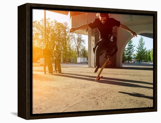Silhouette Skateboarder Jumping in City on Skateboard under the Bridge. in the Background Two Young-Maxim Blinkov-Framed Premier Image Canvas