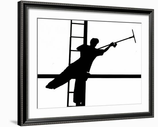 Silhouetted against the Bright Morning Sun, a Window Cleaner Stretches to Clean a Spot-null-Framed Photographic Print