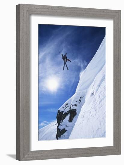 Skier Jumping from Mountain Ledge-null-Framed Photo