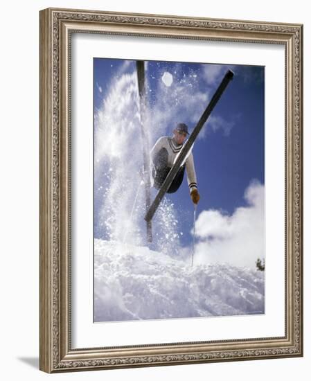 Skier Kicking Up Powder as He Jumps over Hill-George Silk-Framed Photographic Print