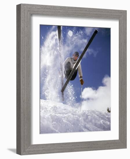 Skier Kicking Up Powder as He Jumps over Hill-George Silk-Framed Photographic Print