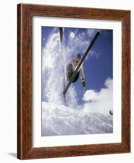 Skier Kicking Up Powder as He Jumps over Hill-George Silk-Framed Photographic Print