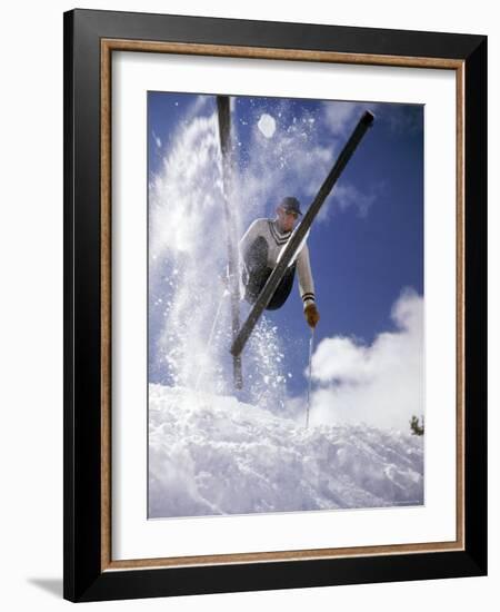 Skier Kicking Up Powder as He Jumps over Hill-George Silk-Framed Photographic Print