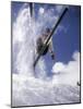 Skier Kicking Up Powder as He Jumps over Hill-George Silk-Mounted Photographic Print