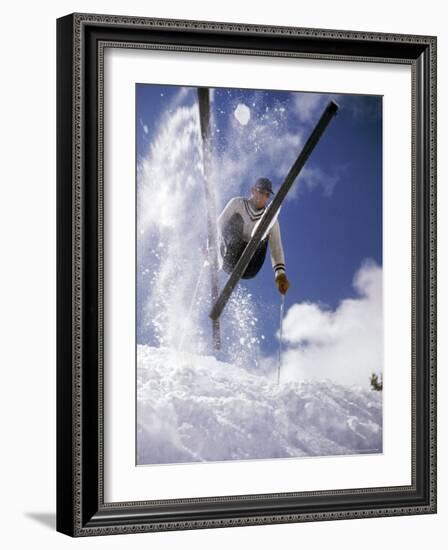 Skier Kicking Up Powder as He Jumps over Hill-George Silk-Framed Photographic Print