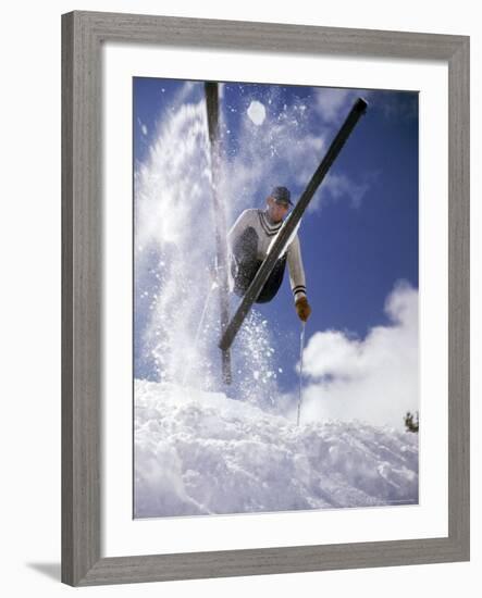 Skier Kicking Up Powder as He Jumps over Hill-George Silk-Framed Photographic Print