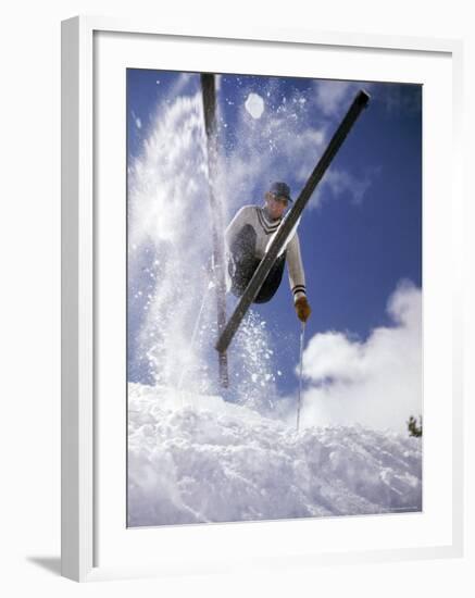 Skier Kicking Up Powder as He Jumps over Hill-George Silk-Framed Photographic Print