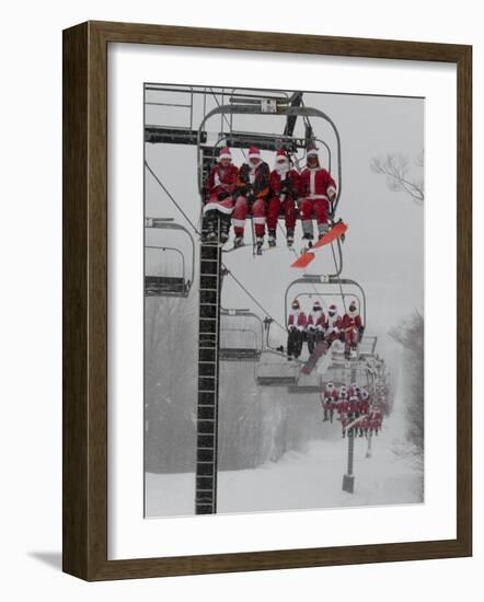 Skiers and Snowboarders Dressed as Santa Claus Ride up the Ski Lift-null-Framed Photographic Print