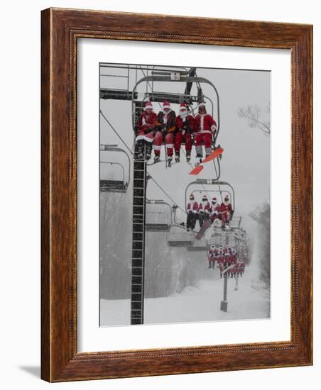 Skiers and Snowboarders Dressed as Santa Claus Ride up the Ski Lift-null-Framed Photographic Print