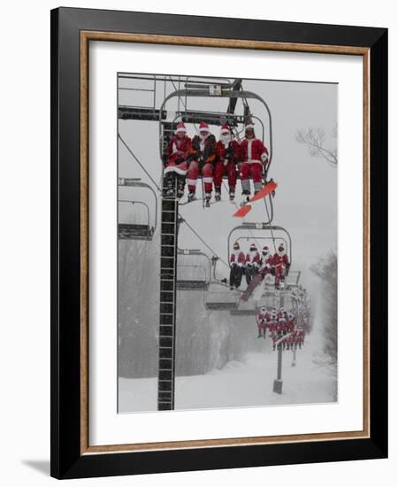 Skiers and Snowboarders Dressed as Santa Claus Ride up the Ski Lift-null-Framed Photographic Print