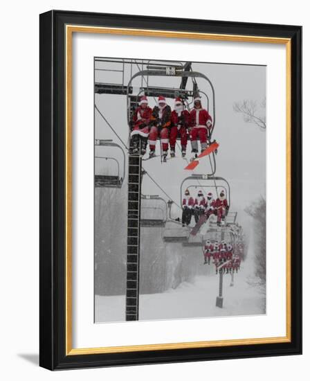 Skiers and Snowboarders Dressed as Santa Claus Ride up the Ski Lift-null-Framed Photographic Print