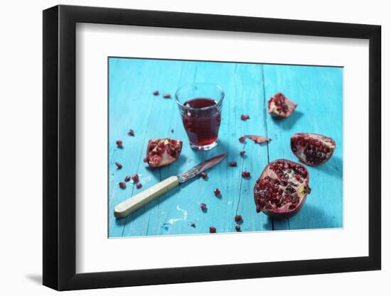 Sliced Pomegranate and a Glass of Pomegranate Juice on Turquoise Wooden Table-Jana Ihle-Framed Photographic Print