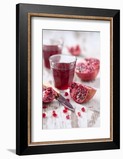 Sliced Pomegranates, Cores and Glass with Pomegranate Juice-Jana Ihle-Framed Photographic Print