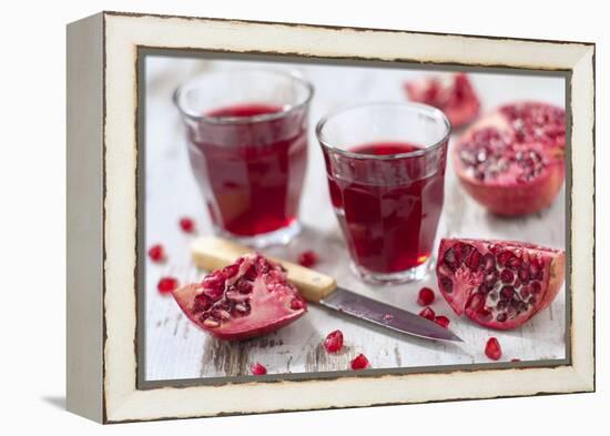 Sliced Pomegranates, Cores and Glasses with Pomegranate Juice-Jana Ihle-Framed Premier Image Canvas
