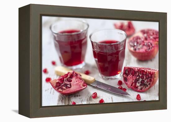 Sliced Pomegranates, Cores and Glasses with Pomegranate Juice-Jana Ihle-Framed Premier Image Canvas
