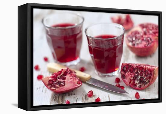 Sliced Pomegranates, Cores and Glasses with Pomegranate Juice-Jana Ihle-Framed Premier Image Canvas