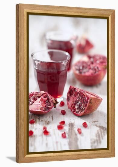 Sliced Pomegranates, Seeds and Glass with Pomegranate Juice-Jana Ihle-Framed Premier Image Canvas