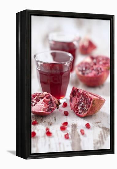 Sliced Pomegranates, Seeds and Glass with Pomegranate Juice-Jana Ihle-Framed Premier Image Canvas