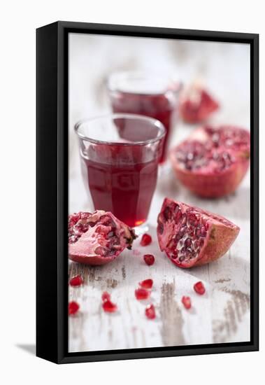 Sliced Pomegranates, Seeds and Glass with Pomegranate Juice-Jana Ihle-Framed Premier Image Canvas