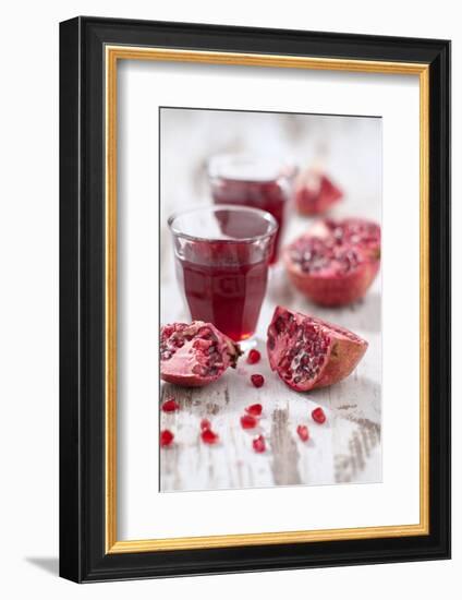 Sliced Pomegranates, Seeds and Glass with Pomegranate Juice-Jana Ihle-Framed Photographic Print