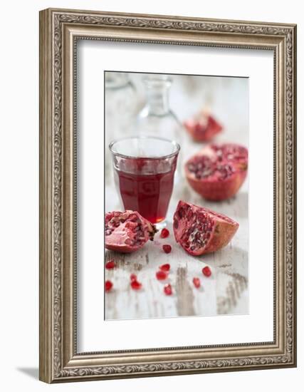 Sliced Pomegranates, Seeds and Glass with Pomegranate Juice-Jana Ihle-Framed Photographic Print