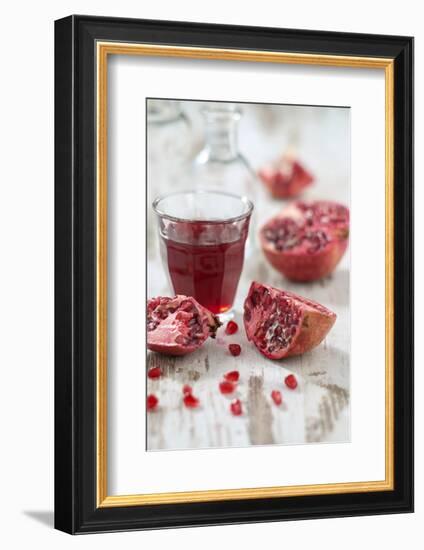 Sliced Pomegranates, Seeds and Glass with Pomegranate Juice-Jana Ihle-Framed Photographic Print