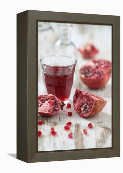 Sliced Pomegranates, Seeds and Glass with Pomegranate Juice-Jana Ihle-Framed Premier Image Canvas