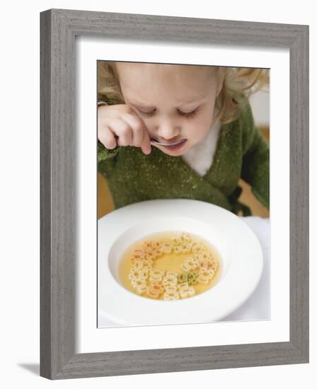 Small Girl Eating Soup with Teddy Bear Pasta-null-Framed Photographic Print