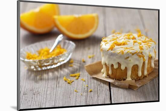 Small Orange Cake with White Icing on Wooden Table-Jana Ihle-Mounted Photographic Print