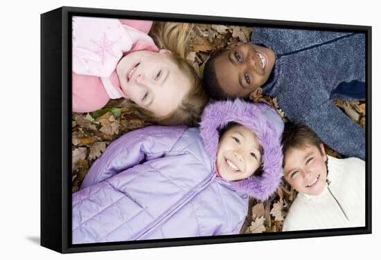 Smiling Children Lying on Autumn Leaves-Ian Boddy-Framed Premier Image Canvas