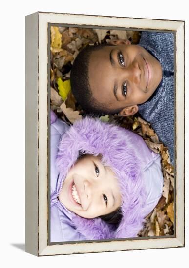 Smiling Children Lying on Autumn Leaves-Ian Boddy-Framed Premier Image Canvas