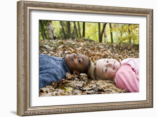 Smiling Children Lying on Autumn Leaves-Ian Boddy-Framed Photographic Print