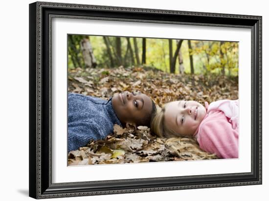 Smiling Children Lying on Autumn Leaves-Ian Boddy-Framed Photographic Print