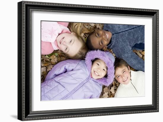 Smiling Children Lying on Autumn Leaves-Ian Boddy-Framed Photographic Print