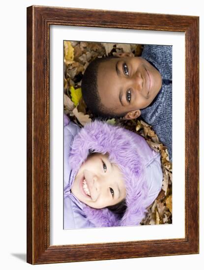 Smiling Children Lying on Autumn Leaves-Ian Boddy-Framed Photographic Print