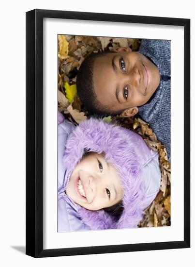 Smiling Children Lying on Autumn Leaves-Ian Boddy-Framed Photographic Print