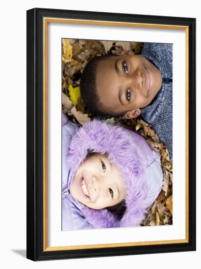 Smiling Children Lying on Autumn Leaves-Ian Boddy-Framed Photographic Print