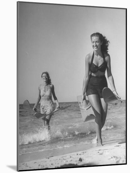 Smiling Girls Carrying Skis Out of the Water onto Beach-null-Mounted Photographic Print