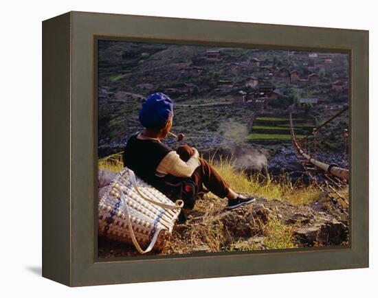 Smoking Her Pipe, a Naxi Woman Rests after Crossing a Precarious Pipe Bridge High Above the Yangtse-Amar Grover-Framed Premier Image Canvas