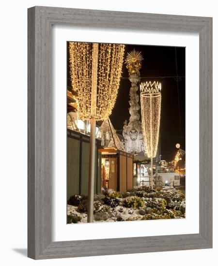 Snow-Covered Flowers, Christmas Decorations and Baroque Trinity Column at Christmas Market, Austria-Richard Nebesky-Framed Photographic Print