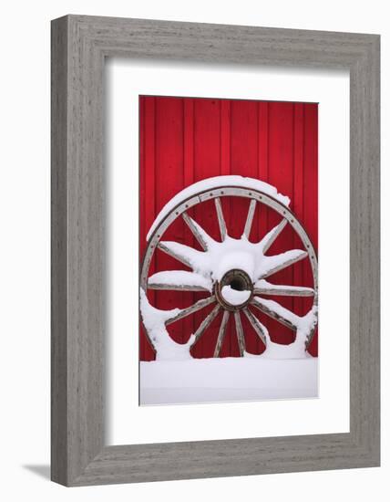 Snow-covered wagon wheels against red barn near town of Banff, Canadian Rockies, Alberta, Canada-Stuart Westmorland-Framed Photographic Print