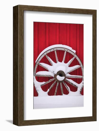 Snow-covered wagon wheels against red barn near town of Banff, Canadian Rockies, Alberta, Canada-Stuart Westmorland-Framed Photographic Print