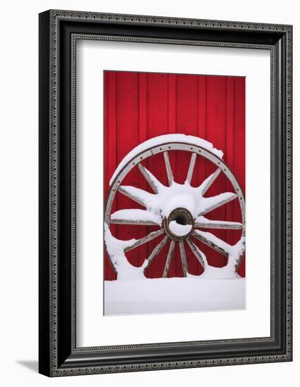 Snow-covered wagon wheels against red barn near town of Banff, Canadian Rockies, Alberta, Canada-Stuart Westmorland-Framed Photographic Print